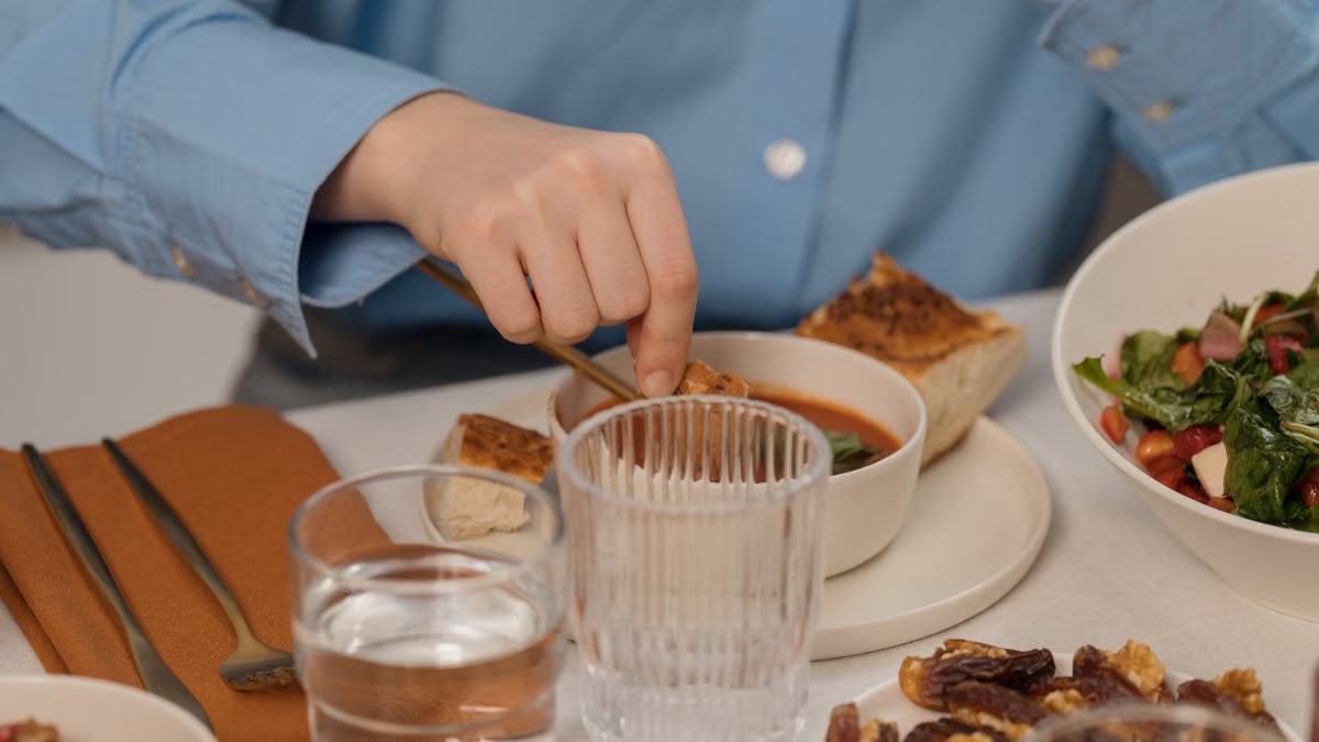 A close-up of a dining setup featuring soup, salad, and elegant tableware, creating a refined dining atmosphere.